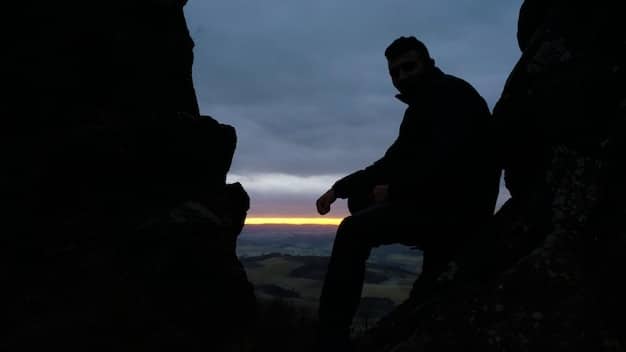 A person reaching out their hand from a dark abyss towards a single ray of light, symbolizing the moment of hitting rock bottom and seeking help for addiction recovery.
