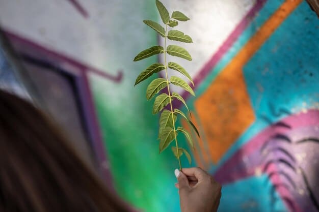 A close-up shot of an artist's hand painting a mural on a building, depicting a polluted cityscape transforming into a green, sustainable urban environment.