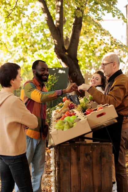 A photo depicting a diverse group of volunteers harvesting fresh produce (vegetables and fruits) in a US community garden. They are placing the harvested items into baskets and crates, with a focus on the vibrant colors and freshness of the food. The background shows rows of cultivated plants and garden plots.
