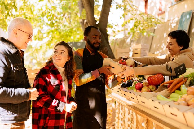 A community event where volunteers are helping to distribute groceries to families in need. The image shows a diverse group of people working together to support their community.
