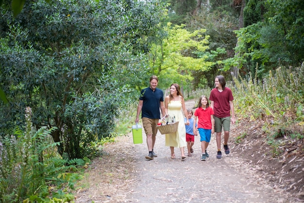A family hiking on a well-maintained trail in a national park, showing the park's infrastructure and the enjoyment of visitors. The focus should be on the trail and the surrounding natural environment, emphasizing the blend of recreation and conservation that attracts visitors and supports local economies.