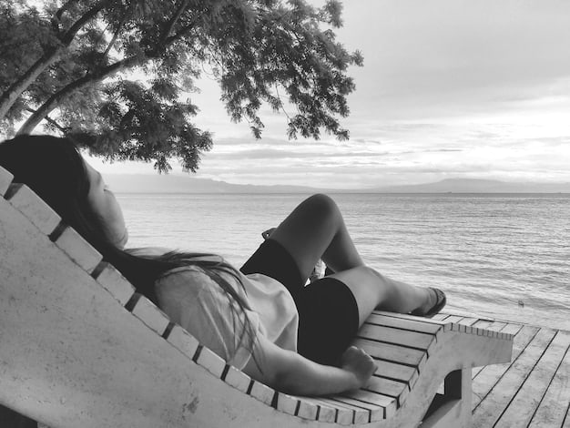 A black and white photograph shows a young person sleeping on a park bench. Their belongings are piled beside them, suggesting homelessness. In the background, city buildings loom, contrasting the individual's vulnerable situation with the symbols of urban success.