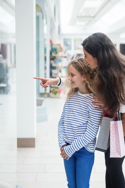 A smiling US single mother interacting with a happy customer in her store. The scene is welcoming and showcases the friendly atmosphere of her business.