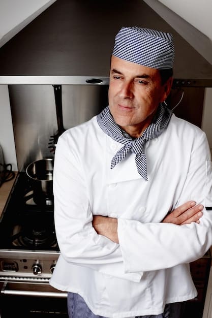 A medium shot of the US chef in their kitchen, wearing a clean chef's coat and a warm smile. They are actively stirring a large pot of food, surrounded by fresh vegetables and other ingredients. The lighting is bright and natural, emphasizing the chef's dedication and passion for cooking while reducing food waste.