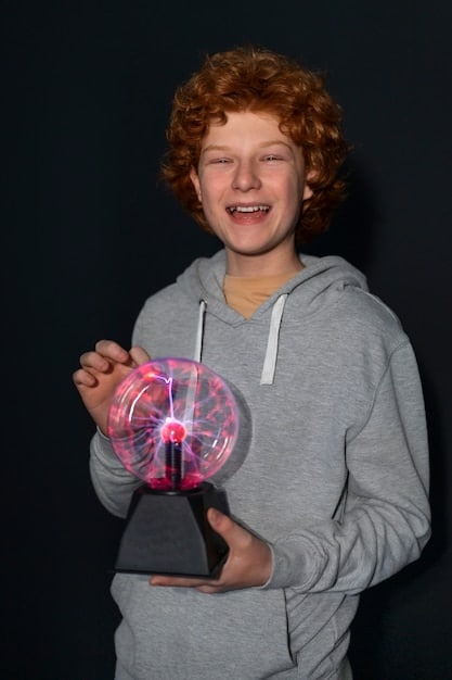 Fionn Ferreira accepting an award on stage at the Google Science Fair, smiling confidently and holding the trophy. The Google logo is visible in the background.