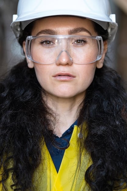 Close-up shot of the US engineer, wearing safety glasses and a hard hat, hands-on working on a component of the water filtration system. The focus is on their skilled hands and determined expression, showcasing their commitment to the project.