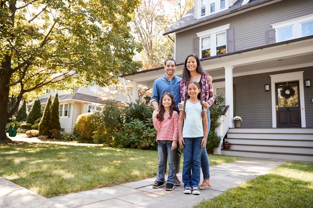 A family smiling in front of a new home, indicating successful homeownership through government assistance programs.
