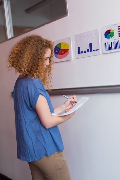 A teacher using an interactive whiteboard to explain complex investment concepts to interested students, showing charts and graphs.