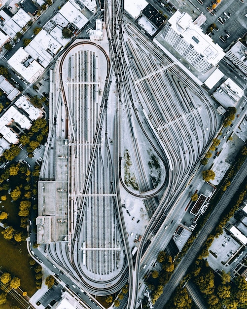 An aerial view of a bustling urban area with a modern light rail system integrated into the streetscape. The light rail cars are sleek and efficient, symbolizing improved public transportation options funded by the US Infrastructure Bill. The surrounding infrastructure is well-maintained, highlighting the positive impact on urban development from the US Infrastructure Bill Update.
