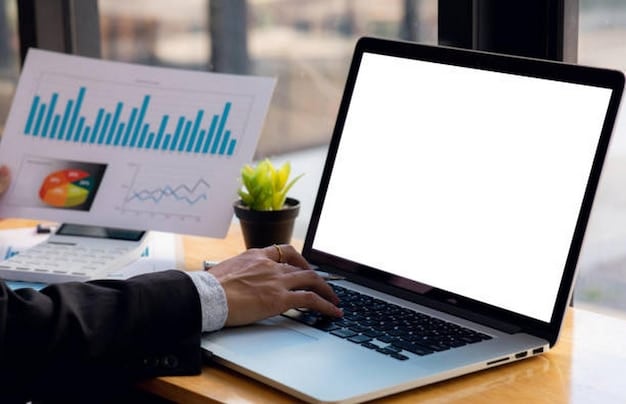 A person working on a laptop with charts and graphs displayed on the screen, showing both upward and downward trends, representing the fluctuating nature of investments in response to Federal Reserve decisions. The title is