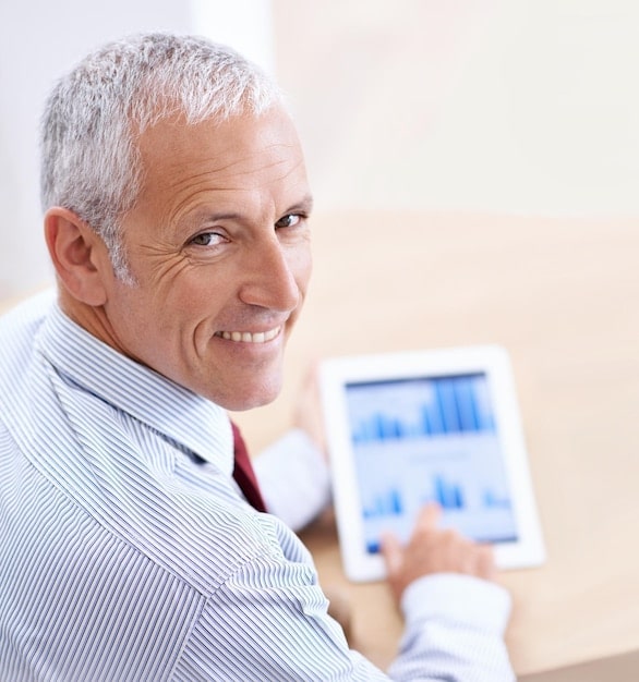 An image illustrating a senior citizen looking at a graph on a tablet, highlighting the increase in Social Security benefits. The graph shows a clear upward trajectory, indicating growth in benefits. The setting is bright and modern, suggesting forward-thinking financial management. Contains elements that evokes feelings of security and confidence in retirement planning.