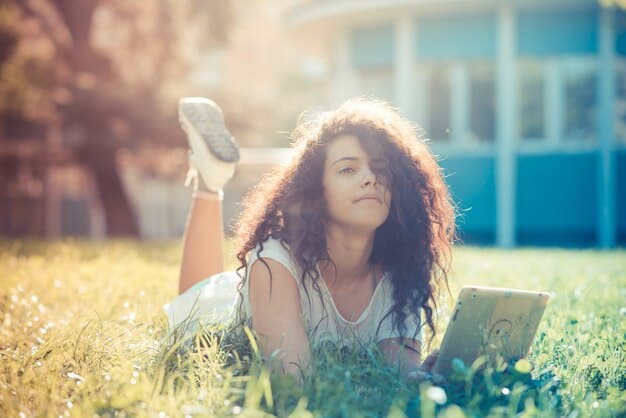 High school student studying with books and smiling, the sunlight on the scene gives it a warm feeling as she is enjoying her time studying.