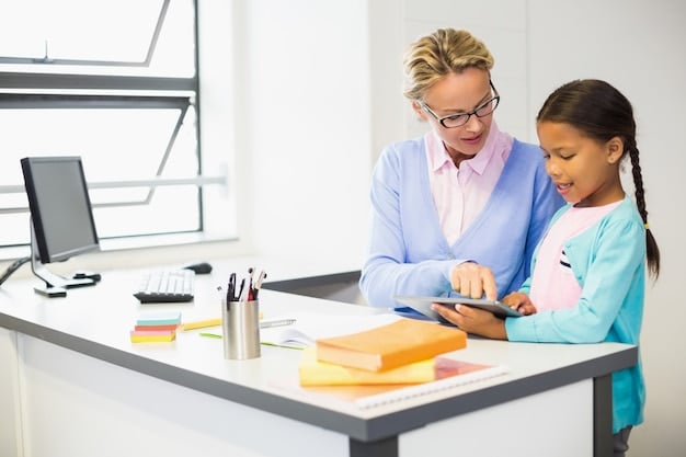 A teacher sitting at a desk, smiling and talking to a student who is standing beside the desk. The teacher is pointing at something on a tablet screen. This shows the importance of teacher-student relationship to improve student outcomes by 10%?